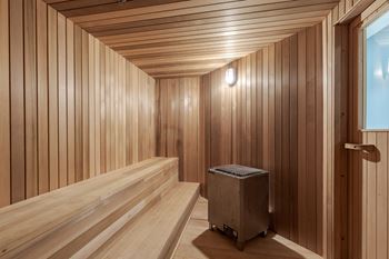 A sauna with wooden walls and a wooden floor and a suitcase